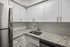 Modern kitchen with stainless steel appliances, granite countertops, and white cabinetry.