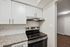 Modern kitchen with sleek white cabinets, granite countertops, and stainless steel appliances.