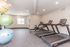 Contemporary fitness room with treadmills, stationary bike, and colorful exercise balls.