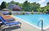 Inviting pool area surrounded by lounge chairs and lush greenery, perfect for relaxation.