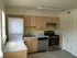 A bright kitchen at Greenbriar Estates featuring light wood cabinetry, modern appliances, and an in-unit washer and dryer for added convenience.