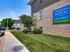 Brick exterior and signage of Sequoia Manor Apartments surrounded by lush greenery and plentiful parking for residents.