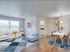 An elegant open-concept living and dining area featuring bright natural light, stylish furnishings, and beautiful hardwood floors for a modern, inviting atmosphere.