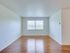 A welcoming open living space featuring a large window and polished hardwood flooring for a bright, airy atmosphere at Sequoia Manor Apartments.