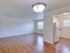 A bright open-concept living and dining area with hardwood flooring, seamlessly connected to the adjacent kitchen for a spacious, flowing layout.