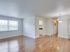 A bright apartment interior featuring hardwood floors, a large window for natural light, and modern lighting for a fresh, inviting atmosphere.