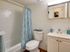 A modern furnished bathroom at Sequoia Manor Apartments featuring elegant fixtures, a white vanity, and a vibrant blue shower curtain for a stylish, clean look.