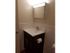 A modern bathroom with a functional vanity, mirror cabinet, and a sink with dark cabinetry.