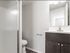 A sleek modern bathroom with a glass-enclosed shower, elegant dark wood vanity, and crisp white walls, creating a clean and sophisticated space.