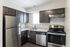 A modern kitchen equipped with sleek stainless steel appliances and stylish dark wood cabinetry, offering a sophisticated cooking space.