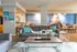 Spacious living room with modern decor, featuring a gray sofa, artistic sculpture, and a nautical mural.