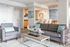 Inviting living room with modern gray sofa, armchair, and unique decor in a bright, open apartment.