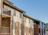 A stylish apartment building with a mix of brick and siding, offering expansive windows and private balconies for a modern living experience.