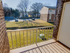 A charming balcony with an outdoor view of lush green spaces and peaceful residential area, perfect for relaxation.