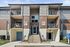 The three-story apartment building with a brick facade, offering private balconies for a comfortable living experience.