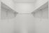 A spacious and well-lit walk-in closet featuring built-in shelving and ample hanging rods for optimal organization.