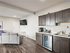A bright and modern open-concept kitchen and living room featuring a stylish cabinetry and elegant furnishings, perfect for contemporary living.