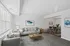 A bright and stylish living room with modern furniture, an elegant dining area, large windows, and contemporary decor.