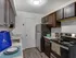 A sleek modern kitchen featuring dark wood cabinets, stainless steel appliances, and elegant countertops.