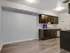 A contemporary kitchen with dark wood cabinets, recessed lighting, and state-of-the-art modern appliances.