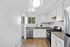 A modern kitchen in The Greenbriar Apartments featuring white cabinets and sleek stainless steel appliances.