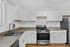 Contemporary kitchen in The Greenbriar Apartments, highlighting stainless steel appliances and fresh white cabinets.