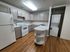 Modern kitchen featuring white appliances and wooden floors at the Residences at Pleasant Ridge Apartments.