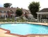 The pool area at the Highlands-at-Warwick, featuring clear water and surrounding lounge chairs in a sunny setting.