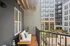 Balcony at Lofts at Yard 56 with a bench, offering a scenic view of the bustling city below.