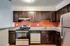 Modern kitchen at Perkins Place Apartments featuring stainless steel appliances and warm wood cabinets.