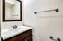 Perkins Place Apartments bathroom showcasing a sink, mirror, and a towel rack for convenience.