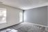 Interior of an empty room in Perkins Place Apartments, with gray walls and carpet, providing a simple and modern look.