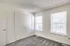 Interior of an empty room at Perkins Place Apartments, showcasing gray carpet and white doors.