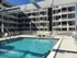 A pool with chairs and umbrellas in front of the 500 Park Avenue Apartments building.