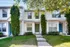 Front view of a two-story townhouse at Perkins Place Apartments, showcasing a charming front yard and welcoming atmosphere.