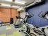 Interior of Lancaster Lofts gym with various exercise equipment and a stylish brick wall backdrop.