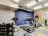 Gym area at Lancaster Lofts showcasing various exercise equipment and a lively, colorful wallpaper on the wall.