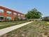 Front yard of Lancaster Lofts featuring a grassy area and landscaping around the apartment building.