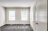 Unfurnished room in Perkins Place Apartments, showcasing carpet and two windows for ample sunlight.