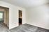 Spacious empty room in Perkins Place Apartments with a cozy carpet and fresh white walls, ready for new decor.