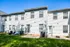 Backyard of Perkins Place Apartments featuring a green lawn and a cozy patio area for residents to enjoy.