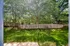 The backyard of Perkins Place Apartments, showcasing a fence surrounded by vibrant trees.