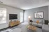 Modern living room in Perkins Place Apartments, showcasing gray furniture and a sleek flat-screen TV.