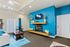 Living room in the Greens at Schumaker Pond apartments, showcasing blue walls and a charming fireplace.