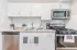 Modern kitchen at Quiet Waters Landing featuring stainless steel appliances and sleek white cabinets.