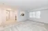 An empty living room in Quiet Waters Landing, with soft carpet and bright white walls, offering a tranquil space.
