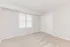 A tranquil empty room at Quiet Waters Landing, showcasing soft carpet and clean white walls.