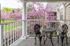 A cozy balcony at The Crest at Elm Tree Apartments featuring two chairs and a small table, perfect for relaxation.