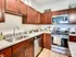 Modern kitchen featuring elegant dark wood cabinets, sleek granite countertops, and stainless steel appliances at Union Flats