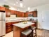 Luxurious kitchen featuring elegant wooden cabinetry, modern stainless steel appliances, and a spacious granite island with stylish barstools at Union Flats.